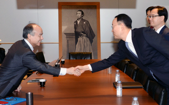 백운규 산업통상자원부 장관(오른쪽)이 8일 일본 도쿄에서 손정의 소프트뱅크 회장을 만나 '동북아 슈퍼그리드' 등 에너지 현안을 논의한 뒤 악수하고 있다.     산업부 제공